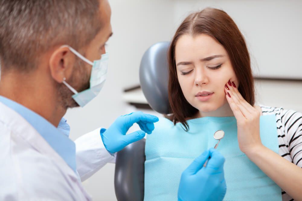 Woman with toothache visiting her dentist