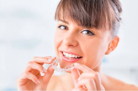 Close-up of woman holding a clear aligner