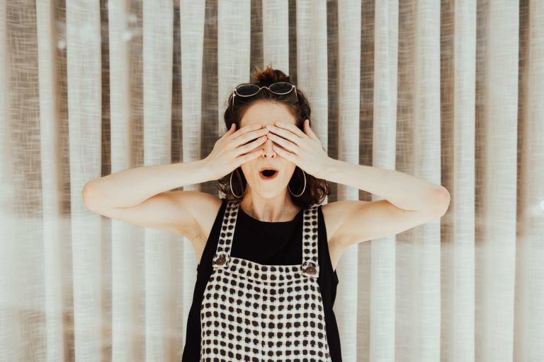 Woman with sunglasses on head covering her eyes