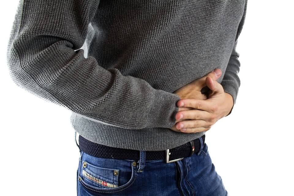 Close-up of man holding his stomach