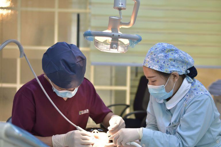 Dentists with masks treating a patient