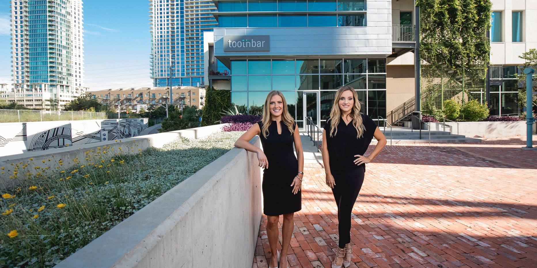 Dr. Lauren Jacobsen and Dr. Kimberley Barclay outside Toothbar in the Seaholm District, under the Toothbar sign
